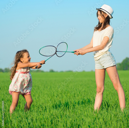 Photo: The young girls plays with a racket in badminton The young girls plays with a racket in badminton