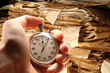 Hand holding stopwatch on document folders background