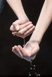From hands drops of water fall