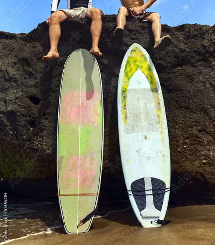 Photo: Two friend surfer sitting on rock Two friend surfer sitting on rock