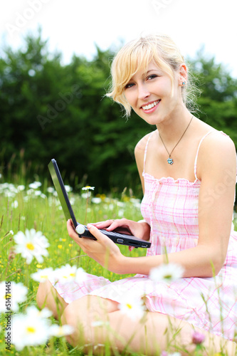 Photo: blonde frau mit laptop auf der wiese blonde frau mit laptop auf der wiese