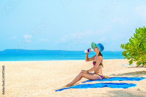 Photo: girl with a bottle of water at the beach girl with a bottle of water at the beach