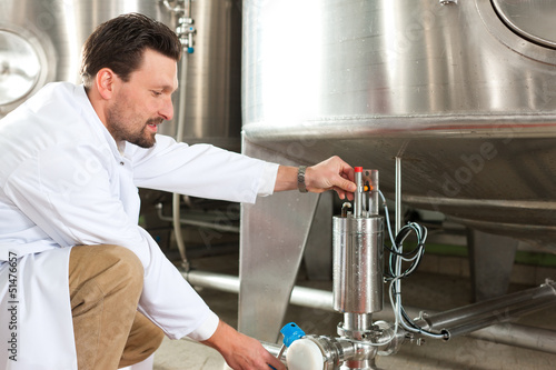 Photo: Beer brewer in his brewery at food tank Beer brewer in his brewery at food tank