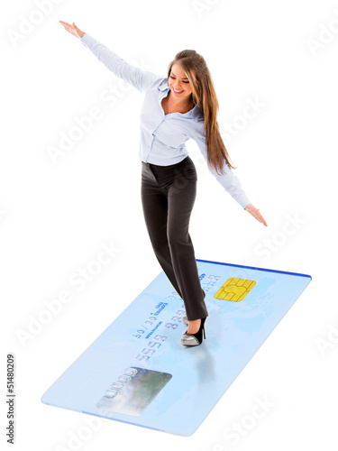 Photo: Business woman flying on credit card Business woman flying on credit card