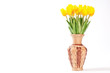 Yellow tulips in a wicker vase on a white background.