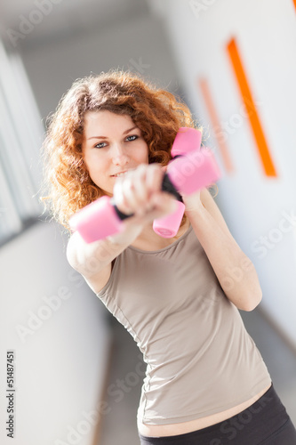 Photo: Young woman doing exercise with dumbbells Young woman doing exercise with dumbbells