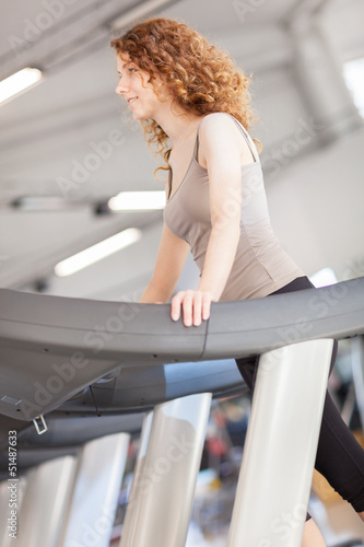 Photo: Woman is doing workout on a treadmill Woman is doing workout on a treadmill