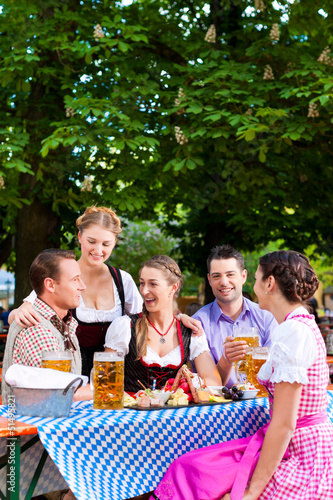 Photo: In Beer garden - friends on a table with beer In Beer garden - friends on a table with beer