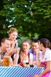 Foto: In Beer garden - friends on a table with beer In Beer garden - friends on a table with beer
