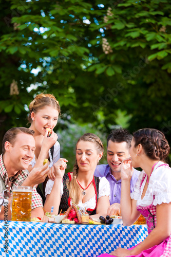 Photo: In Beer garden - friends on a table with beer In Beer garden - friends on a table with beer