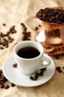 Cup and pot of coffee on beige background