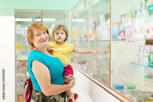 Photo: woman with child chooses at pharmacy woman with child chooses at pharmacy