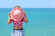 Girl hiding behind a hat
