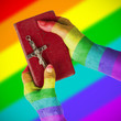 Old hands holding a very old bible, rainbow flag pattern