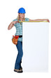 Tradeswoman measuring a blank sign