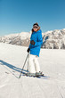 Ski woman in snow mountain landscape with blue sky.