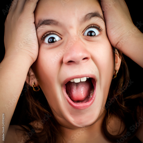 Photo: Girl screaming loudly on a black background Girl screaming loudly on a black background