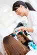 Hairdresser blowing woman's hair