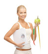 sporty woman with scale, apple and measuring tape