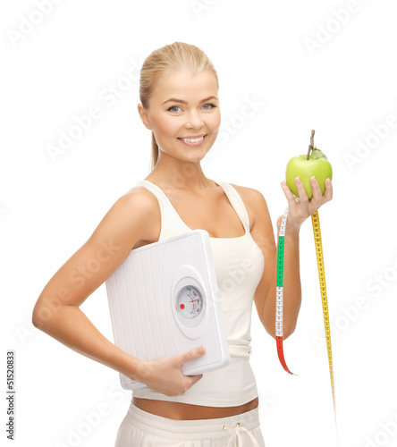 Photo: sporty woman with scale, apple and measuring tape sporty woman with scale, apple and measuring tape