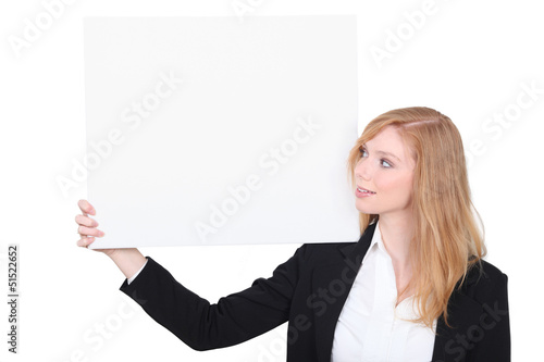 Photo: Woman in a suit with a board left blank for your message Woman in a suit with a board left blank for your message
