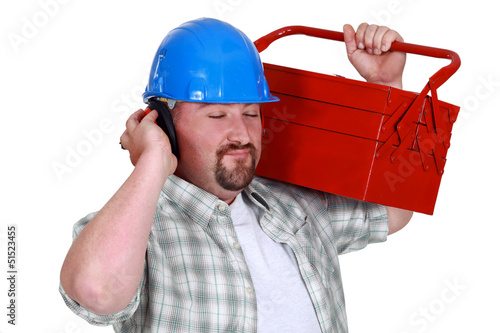 Photo: Tradesman pretending to listen to music Tradesman pretending to listen to music