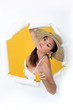 Woman with orange juice bursting out of a paper screen
