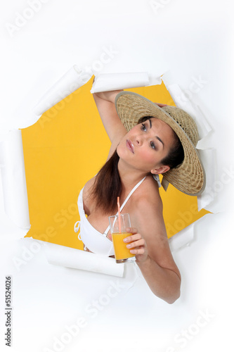 Photo: Woman with orange juice bursting out of a paper screen Woman with orange juice bursting out of a paper screen