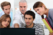 Older students and teacher gathered round a computer