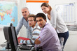 Group of casually dressed people working round a computer