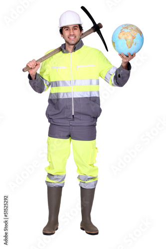 Photo: Labourer holding a globe and a pickaxe Labourer holding a globe and a pickaxe