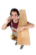 Photo: Worker on the phone while carrying wooden flooring Worker on the phone while carrying wooden flooring