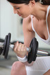Pretty brunette lifting barbell