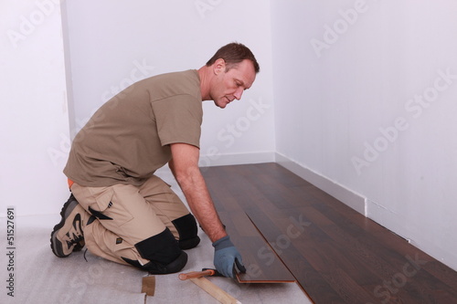 Photo: Man installing parquet flooring Man installing parquet flooring