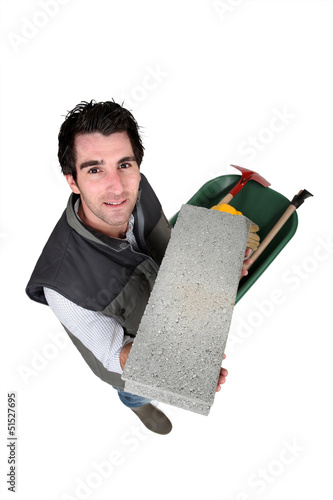 Photo: Mason carrying a breeze block. Mason carrying a breeze block.