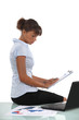 Photo: Woman sat with laptop and clip-board Woman sat with laptop and clip-board
