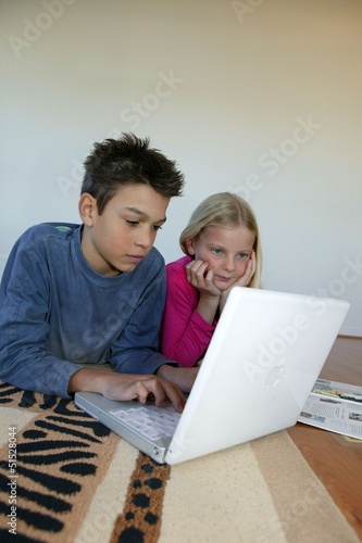 Photo: Brother and sister doing their homework together Brother and sister doing their homework together