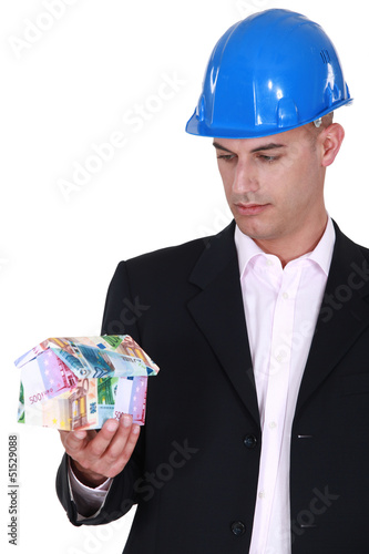 Photo: Architect holding house made from euro bank notes Architect holding house made from euro bank notes