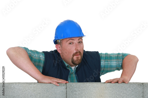 Photo: Bearded mason stood by unfinished wall Bearded mason stood by unfinished wall