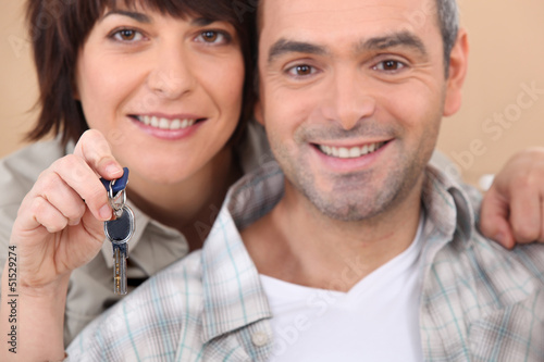 Photo: Mature couple holding up a set of keys Mature couple holding up a set of keys