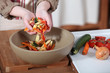 Photo: Woman putting vegetable peeling into bowl Woman putting vegetable peeling into bowl