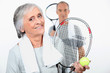 Elderly couple playing tennis