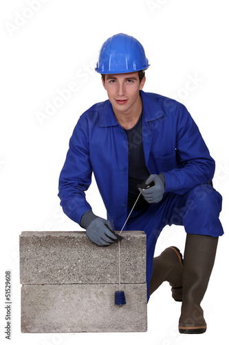 Photo: Bricklayer in blue overalls Bricklayer in blue overalls