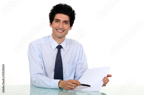 Photo: Man drawing attention to paper Man drawing attention to paper