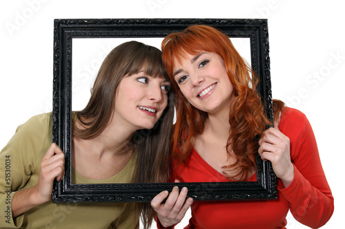 Photo: Two girls behind black frame Two girls behind black frame