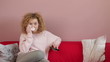 Young woman with remote control watching tv and crying