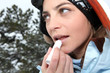 Female skier applying lip balm