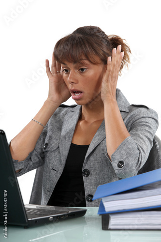 Photo: Alarmed woman looking at her laptop Alarmed woman looking at her laptop