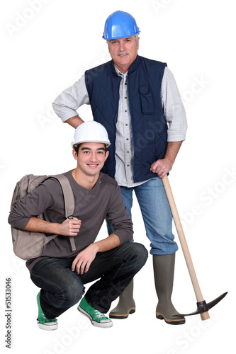 Photo: Experienced tradesman posing with his new apprentice Experienced tradesman posing with his new apprentice