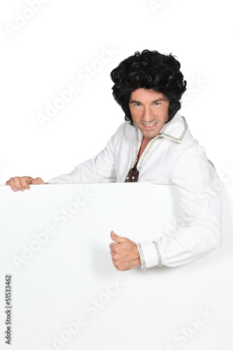 Photo: Man in an Elvis outfit and a board left blank for your image Man in an Elvis outfit and a board left blank for your image